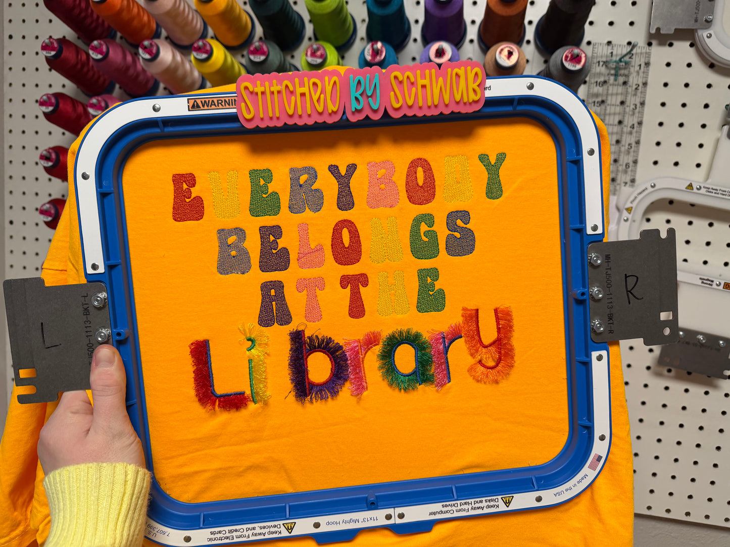 Everybody Belongs at the Library – Colorful Fringe Embroidered Orange Tee